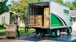Des hommes d’affaires qui se serrent la main avec des camions Enterprise en arrière-plan
